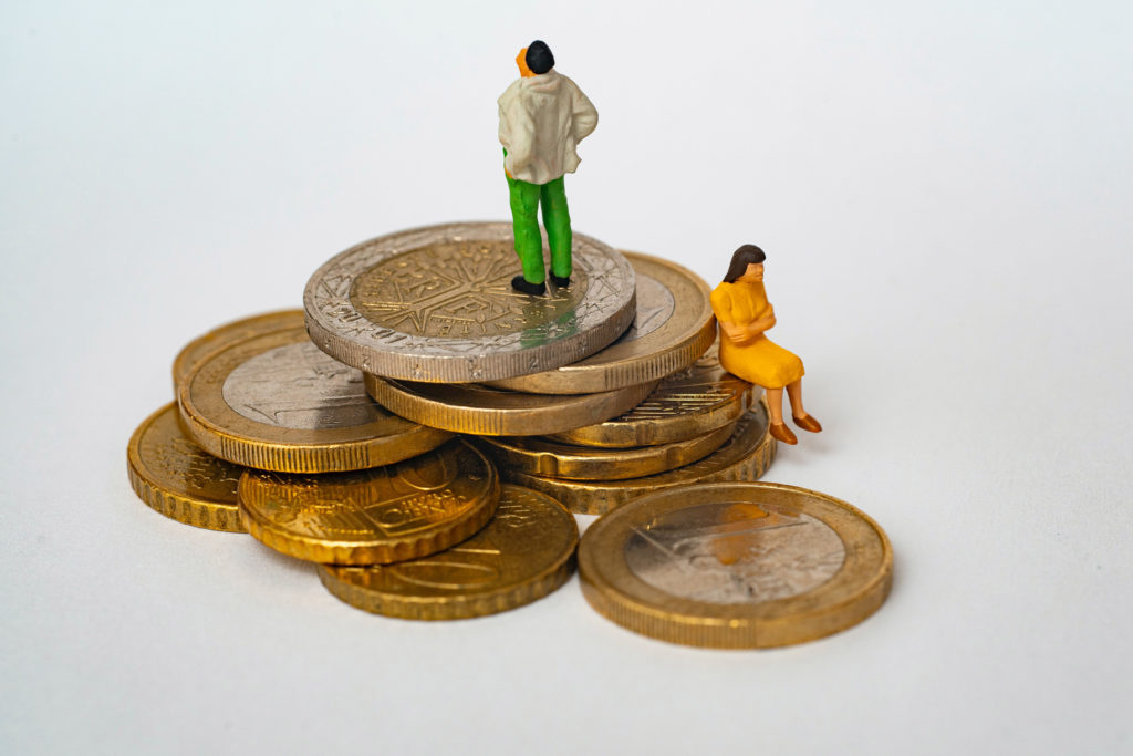 two plastic figures of a man and women standing on a pile of coins representing SSI payment